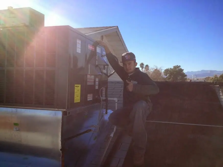 HVAC technician performing AC Tune-Up on a rooftop unit in Tellico Village
